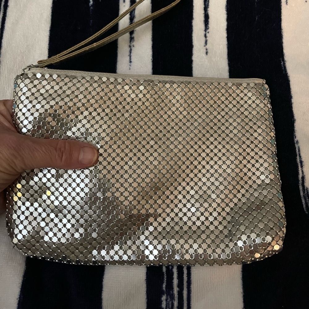 Wristlet or makeup bag. Metallic mesh material with lining and wristlet handle.
